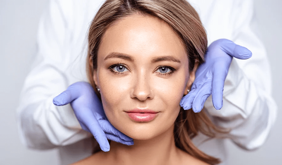 Attractive blond middle aged woman with doctor hands on her face